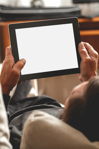 Senior holding a tablet in hands - Foto, afbeelding