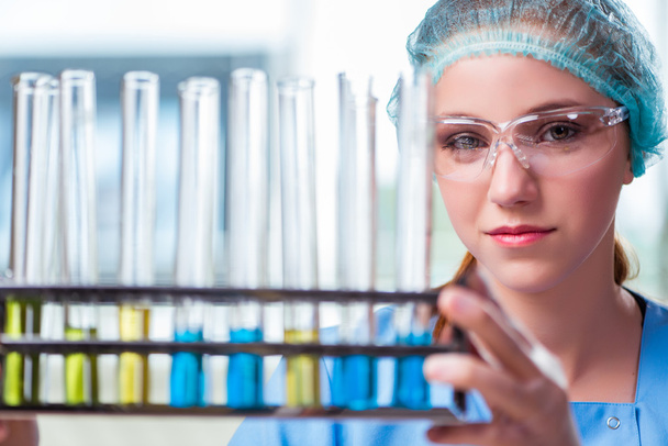 Νεαρός φοιτητής εργάζεται με χημικά διαλύματα στο εργαστήριο - Φωτογραφία, εικόνα