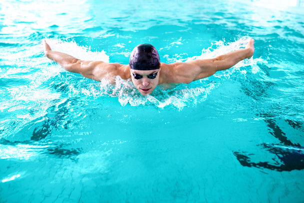 Muscular athlete swimming in pool - Photo, Image