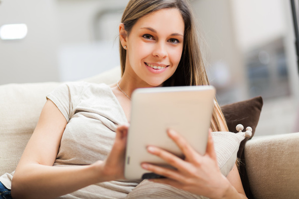 Γυναίκα, χρησιμοποιώντας έναν υπολογιστή tablet στο διαμέρισμά της - Φωτογραφία, εικόνα