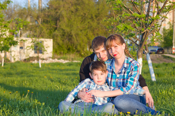 Family sitting on the grass in the park - Foto, imagen