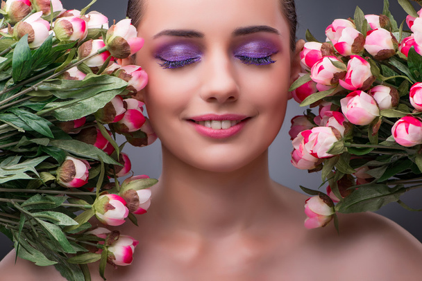 Young woman with flowers in beauty concept - Photo, Image