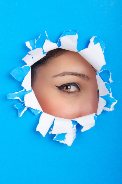 Female face through the hole in paper - Foto, Imagem