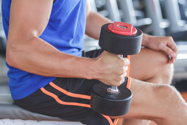 male arm holding and lifting dumbbell  - Foto, immagini