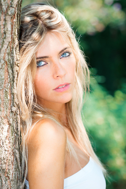 Porträt eines schönen blonden Mädchens mit blauen Augen in der Natur - Foto, Bild