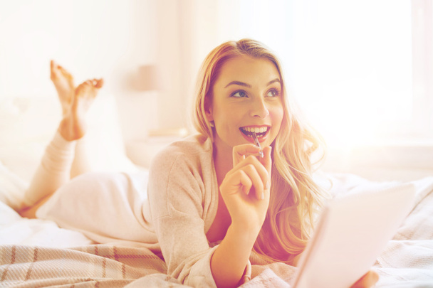 happy young woman with notebook in bed at home - Foto, imagen