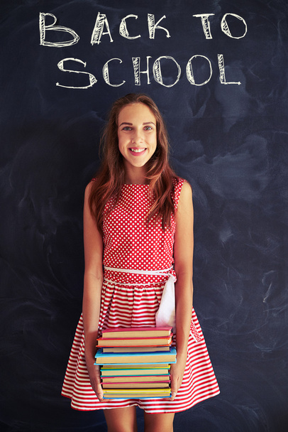 Pretty teenage girl with a pile of books ready for new school ye - Фото, зображення