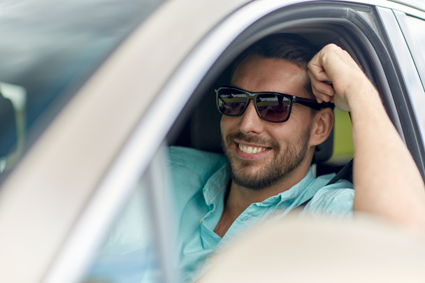 happy smiling man in sunglasses driving car - Photo, image
