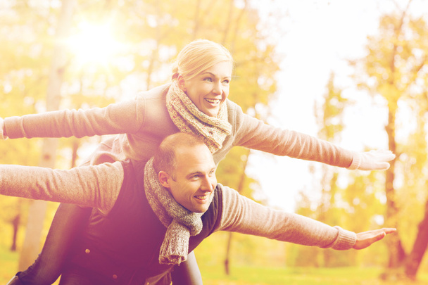 smiling couple having fun in autumn park - Фото, изображение