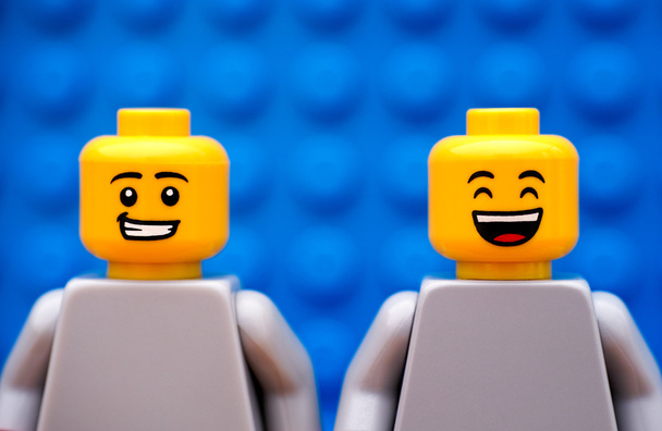 Two Lego minifigures - one with smirk and second happy - Foto, afbeelding