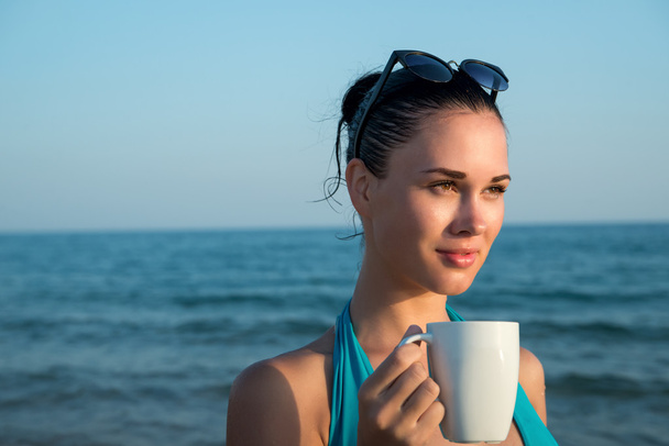 Photograph of a beautiful brunette woman with white mug with tea - Foto, immagini