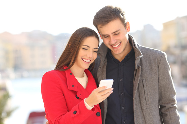 Couple sharing smart phone in winter - Foto, Imagem