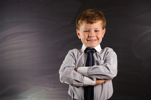 schattige jongen tegen schoolbord - Foto, afbeelding