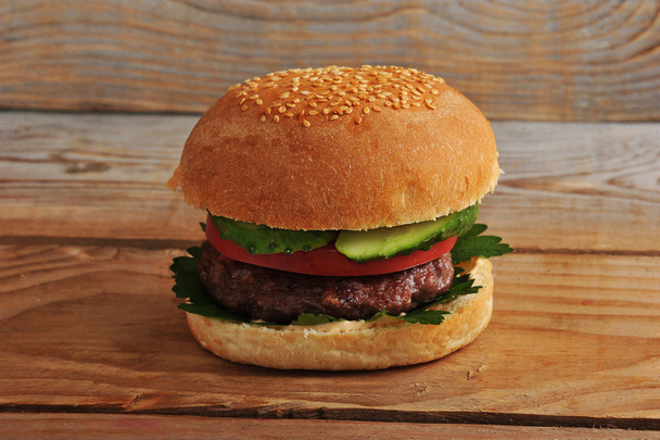 one hamburger on wooden background - Photo, Image