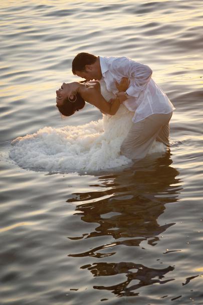Newlywed couple dancing in water - Fotoğraf, Görsel