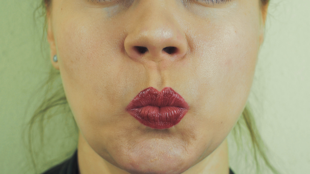 Femme avec des lèvres de morsure de pommade rouge devant la caméra. La bouche. Souris. Langue
. - Séquence, vidéo