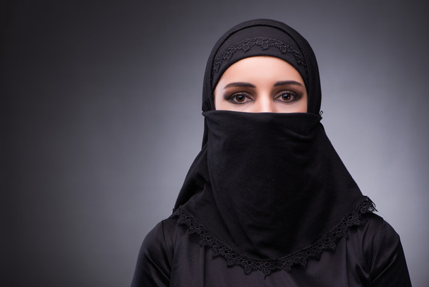 Muslim woman in black dress against dark background - Photo, Image