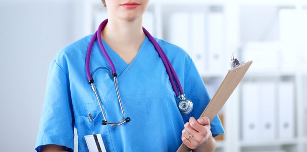 Woman doctor standing with folder at hospital - Foto, immagini