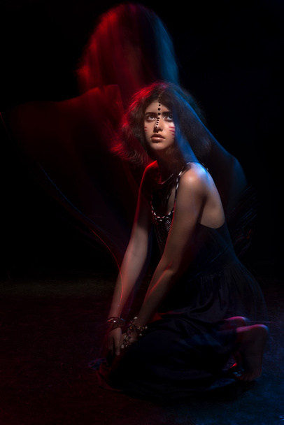 Art fashion portrait of beautiful young woman with tribal styling. Mixed light - Photo, Image