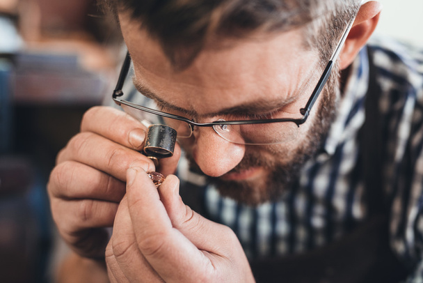 jeweler using loupe to examine gem - Фото, изображение