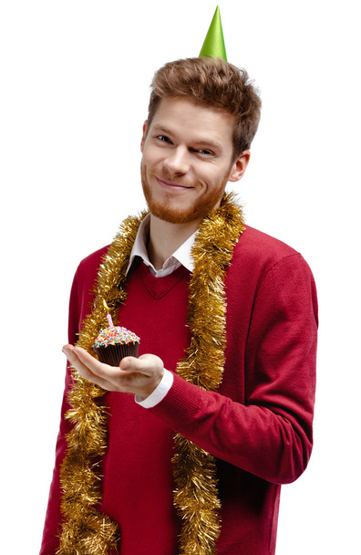 Smiley man with tinsel holds small cake - Foto, afbeelding