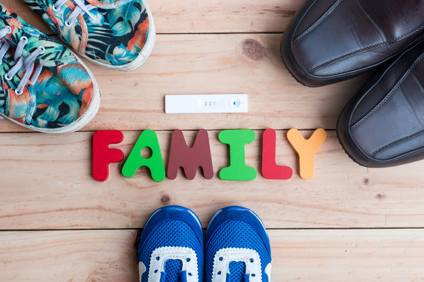 Shoes for the entire family and new member with family alphabet on the wooden floor - Photo, Image