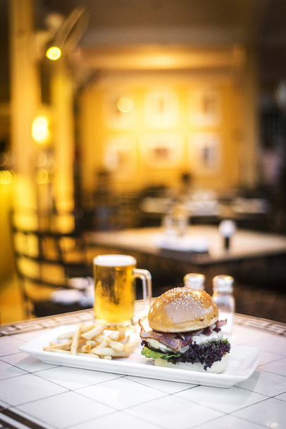 フライド ポテトやビールとチーズとベーコンのグルメ牛肉のハンバーガー - 写真・画像