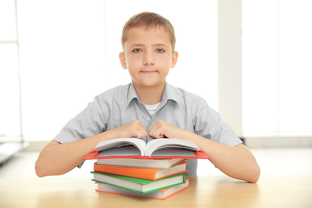 Smiling boy with many books at school - Zdjęcie, obraz