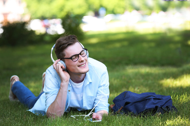 man lying on grass and listening music - Fotografie, Obrázek