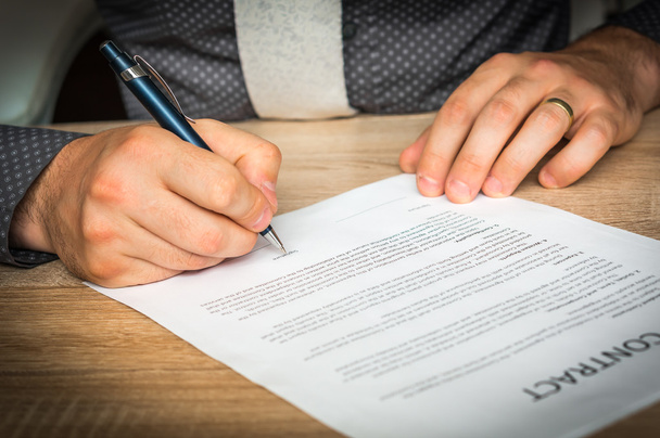 Un homme d'affaires signe un contrat pour conclure un accord
 - Photo, image