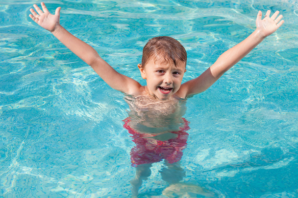 yksi onnellinen lapsi leikkii uima-altaalla päivällä
. - Valokuva, kuva