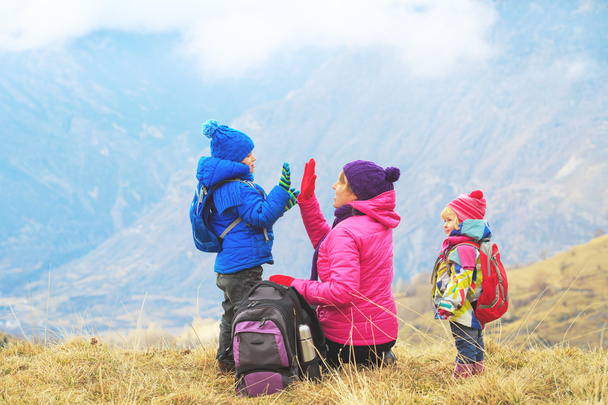 madre feliz y dos niños viajan en las montañas de invierno
 - Foto, imagen