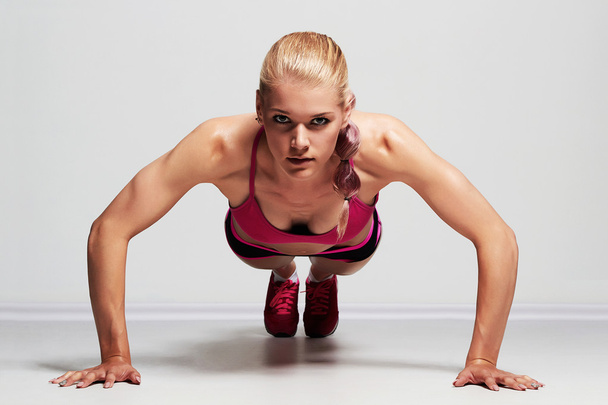 athletic girl.muscular fitness woman doing exercise on the floor.trained female body - Photo, Image