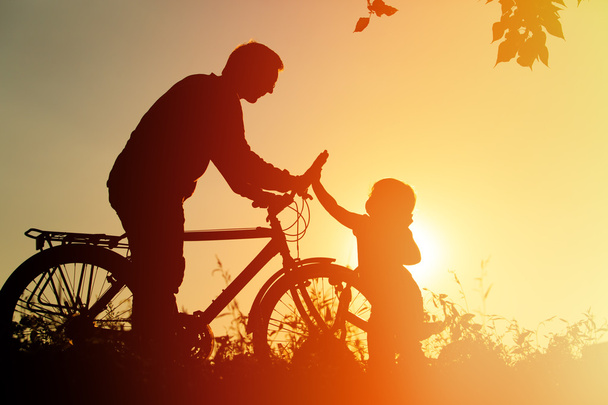 πατέρας και κόρη διασκέδαση ιππασία ποδήλατο στο ηλιοβασίλεμα, ενεργό άθλημα της οικογένειας - Φωτογραφία, εικόνα
