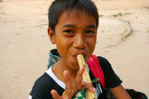 Asiático chico jugando flauta
 - Foto, imagen