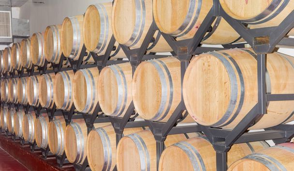 Вино в нових дубових бочках на стелажі
 - Фото, зображення