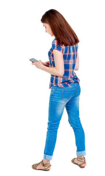 back view of standing young beautiful  woman using a mobile phon - Foto, Imagen