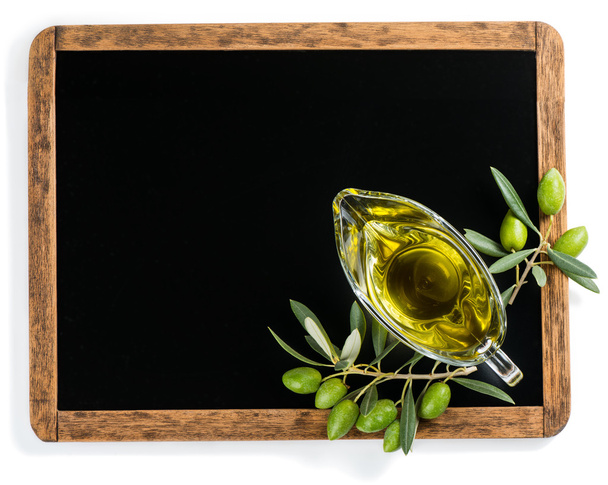 Olive oil, olive fruits with black chalkboard, above view. - Photo, image