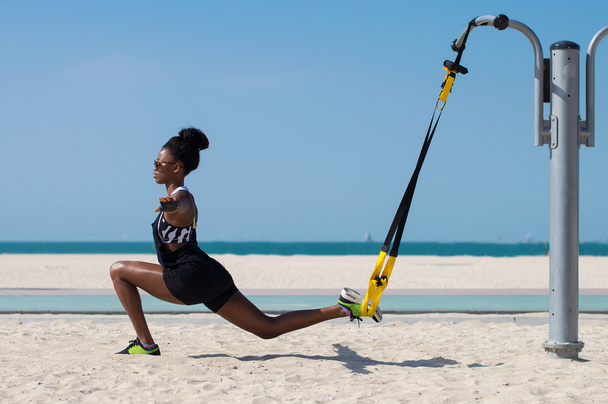 Afrikanische Athletin balanciert mit Hilfe eines Fahrwerkstrainers. Sport im Freien - Foto, Bild