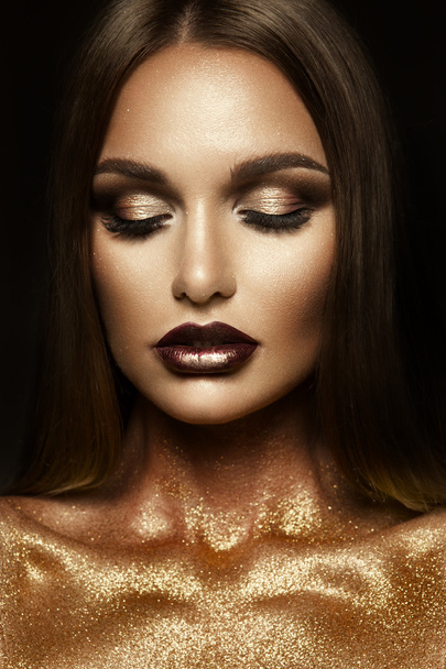 Beautyful meisje met gouden glitter op haar gezicht - Foto, afbeelding