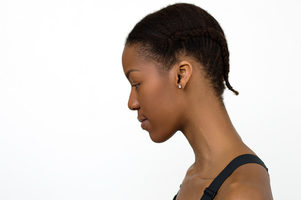Mujer africana sobre fondo blanco con pelo trenzado. Peinado para actividades deportivas
 - Foto, Imagen
