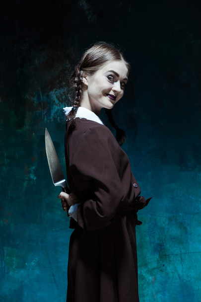 Portrait of a young girl in school uniform as killer woman - Photo, Image