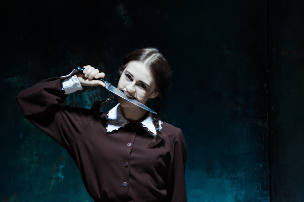 Portrait of a young girl in school uniform as killer woman - Фото, зображення