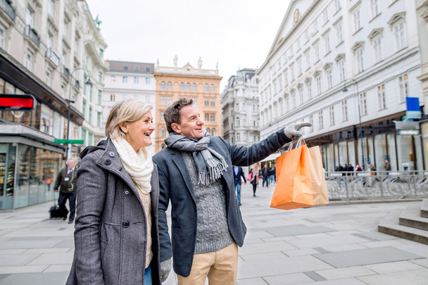 Senior couple shopping in center of city.  - Фото, изображение