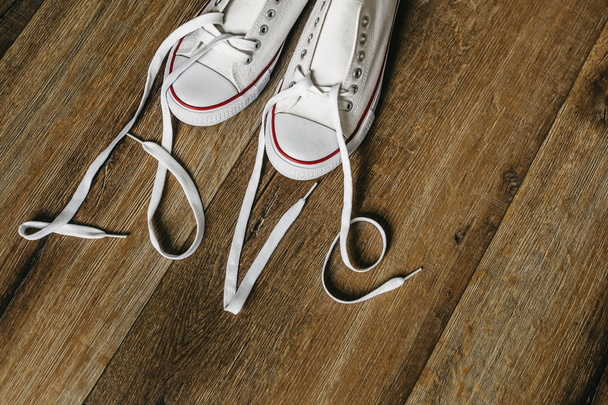 Inscription love with laces on shoes. Original Valentines Day love concept. Wooden floor background. - Photo, image