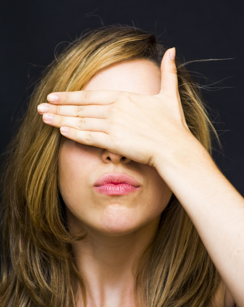 Portrait of a beautiful woman  covering her eyes with her hands - Foto, imagen