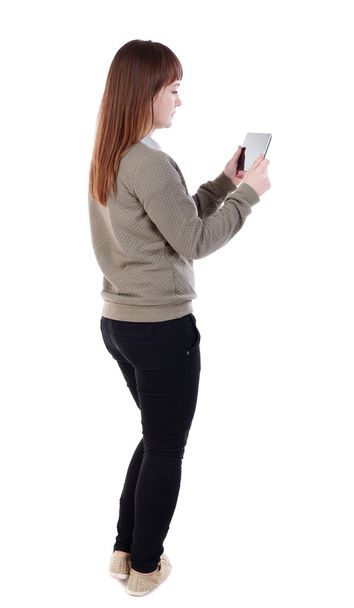 back view of standing young beautiful  woman  using a mobile pho - Photo, image