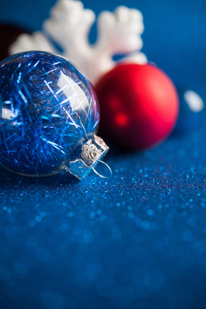Weiße, silberne und rote Weihnachtsornamente auf dunkelblauem Glitzerhintergrund mit Platz für Text. Frohe Weihnachten. Winterurlaub. - Foto, Bild