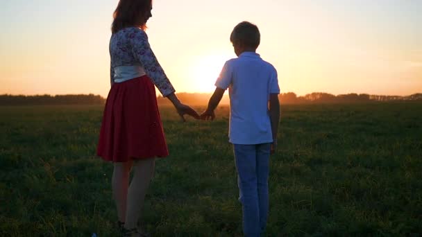 boy with little girl hold hands at sunset - Footage, Video