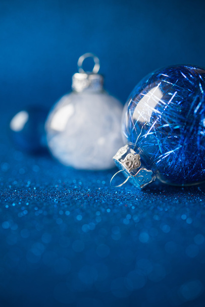 Weißer und blauer Weihnachtsschmuck auf dunkelblauem Glitzerhintergrund mit Platz für Text. Frohe Weihnachten. Winterurlaub. Weihnachtsthema. Frohes neues Jahr. - Foto, Bild